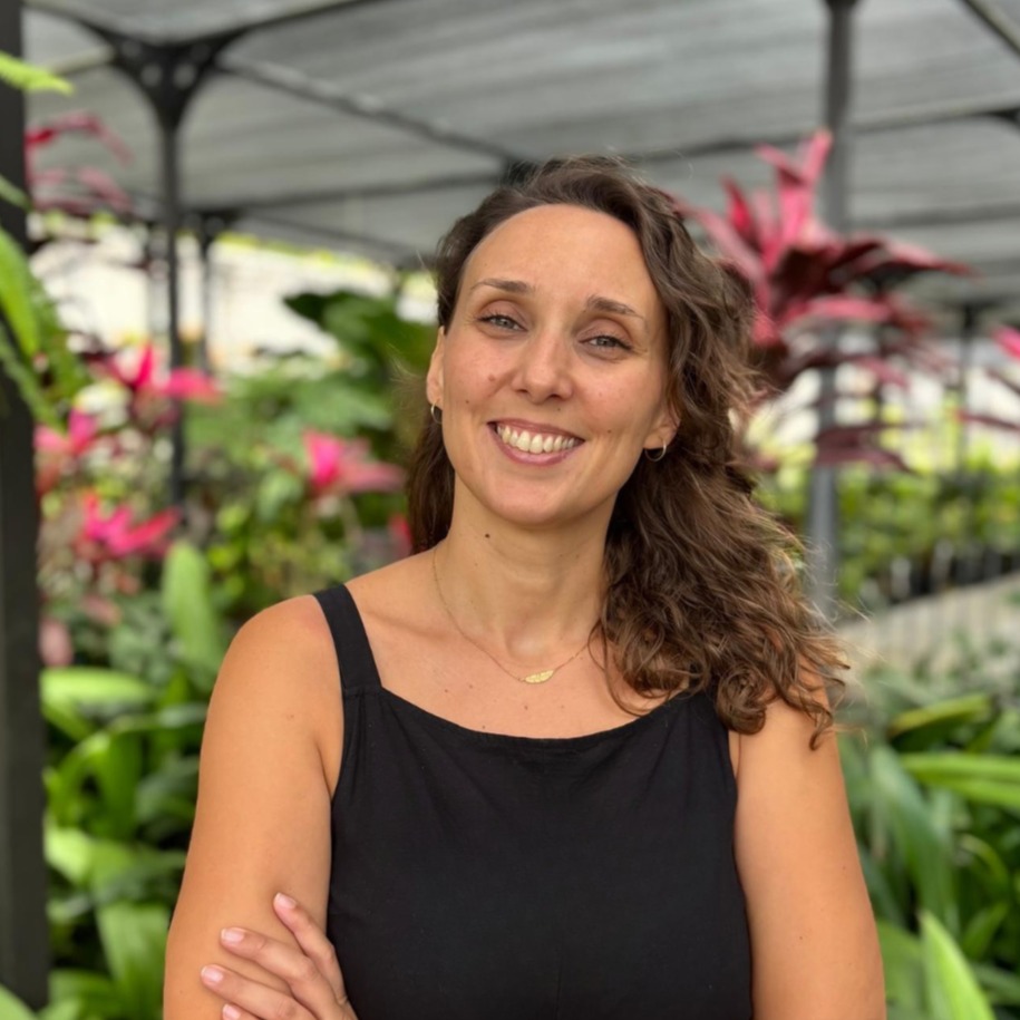 L&eacute;na, sophrologue sp&eacute;cialis&eacute;e en p&eacute;rinatalit&eacute;, souriante dans une serre tropicale